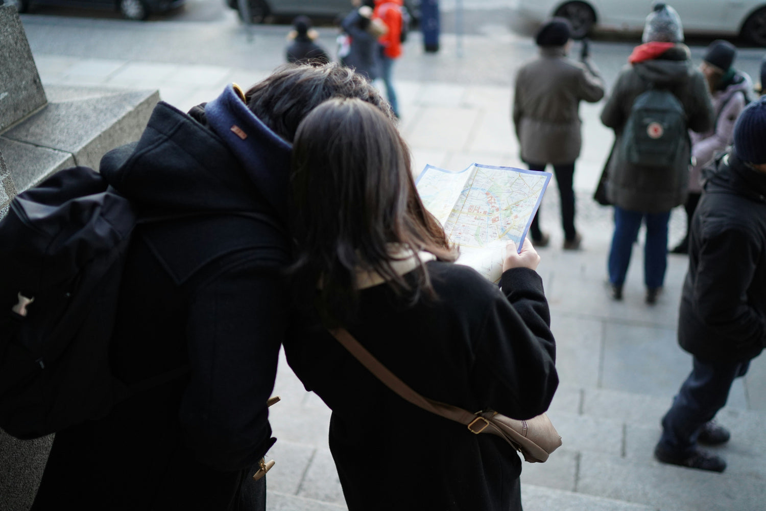 Touristen in Berlin mit einer Stadtkarte, welche sich zu einer Empfehlung von no tourist info begeben.
