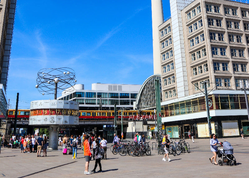 Weltzeituhr, Alexanderplatz und Bahnhofshalle mit Besuchern und Sonnenschein. 
