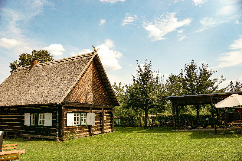 Foto von einem alten Bauernhaus mit Zaun und Bäumen in einem Dorf im Spreewald. 