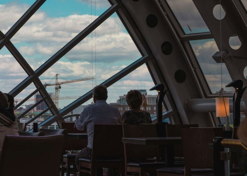 Ein Pärchen sitzt einem an einem Tisch mit guter Aussicht im Kadewe Berlin. 