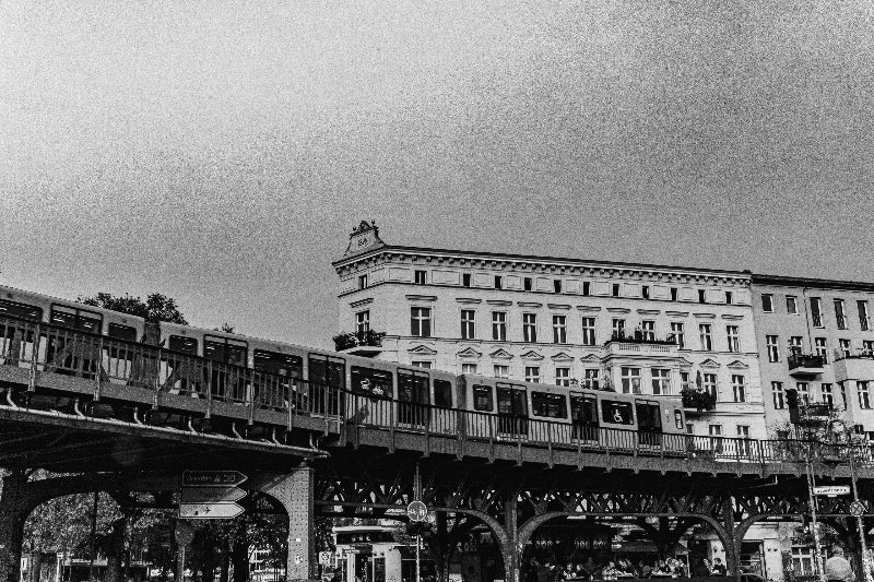 Foto in schwarz weiss von einer Bahnbrücke in Berlin. 