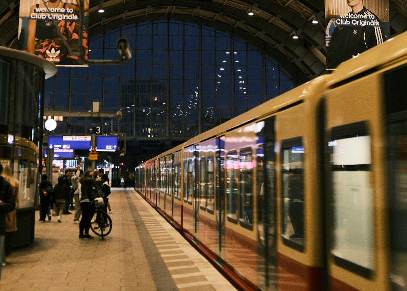 Bahnhofshalle Berlin Alexanderplatz mit wartenden Fahrgästen auf den Zug bei Dunkelheit. 