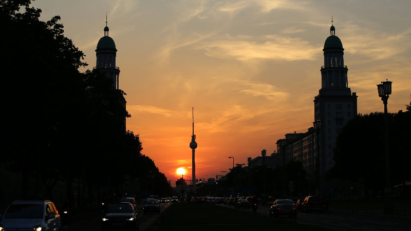Foto von der Frankfurter Alle bei Sonnenuntergang mit Blick auf den Fernsehturm und die beiden Friedrichshain Türme. 