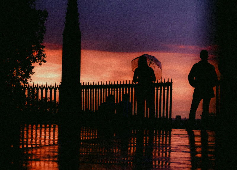 Menschen mit Regenschirm vor einem Gutter bei Gewitter und Regen. 