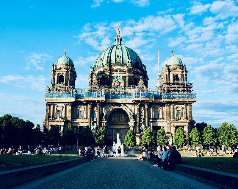 Eingezäunter Berliner Dom mit Baugerüst und strahlend blauem Himmel. 