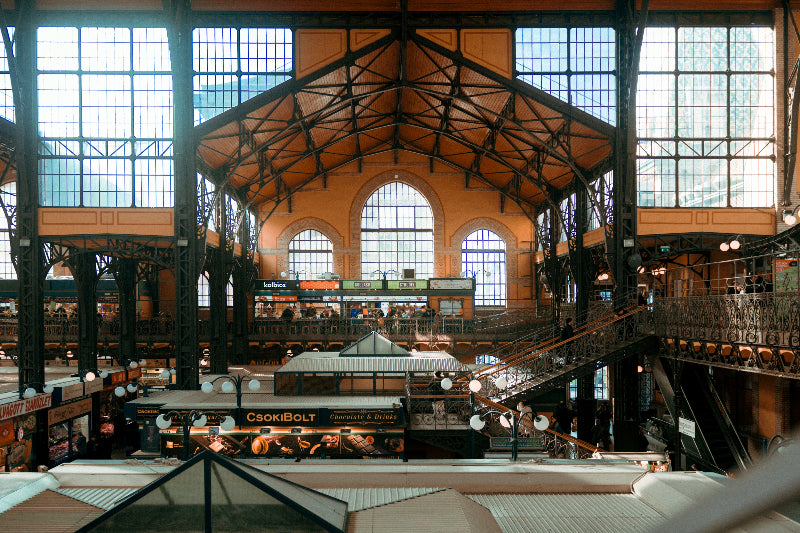 Foto vom Innenbereich einer riesigen Markthalle mit großen Fenstern und vielen Treppen