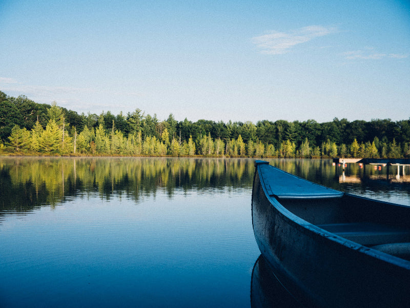 Foto von einem blauen Ruderboot aus Holz auf einem Berliner See. 