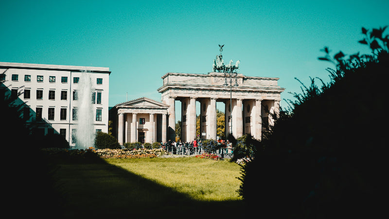 Vom Sonnenschein angestrahltes Brandenburger Tor mit Springbrunnen am Pariser Platz. 