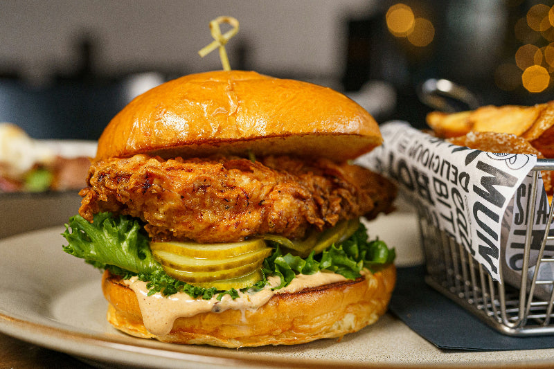 Foto von einem hochwertigen Burger mit Pommes und verschwommenen Restauranthintergrund