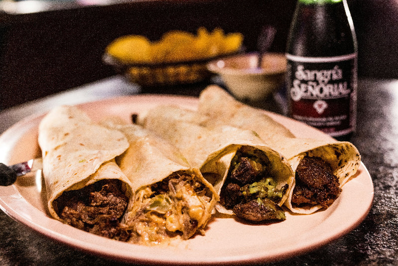 Teller mit 4 Burritos mit Fleisch und Beilagen. 