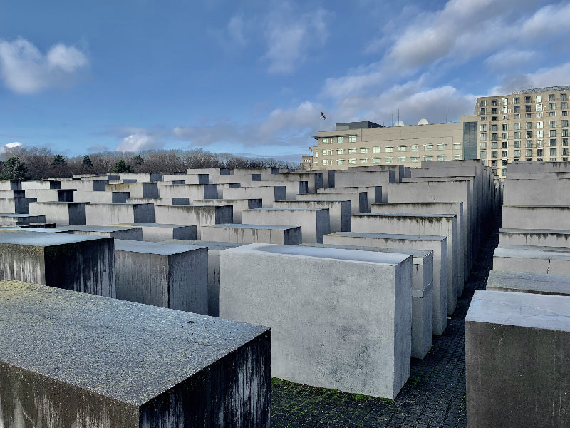 Beton Stelen vom Holocaust Mahnmal und Berliner Wohnhäuser im Hintergrund. 