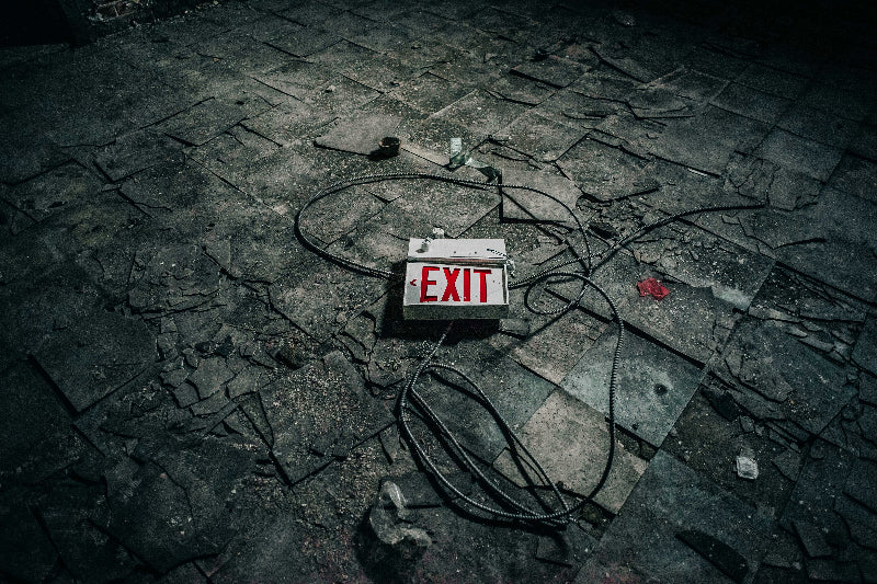 Foto von einem "EXIT" Schild auf einem alten Boden und Kabeln. 