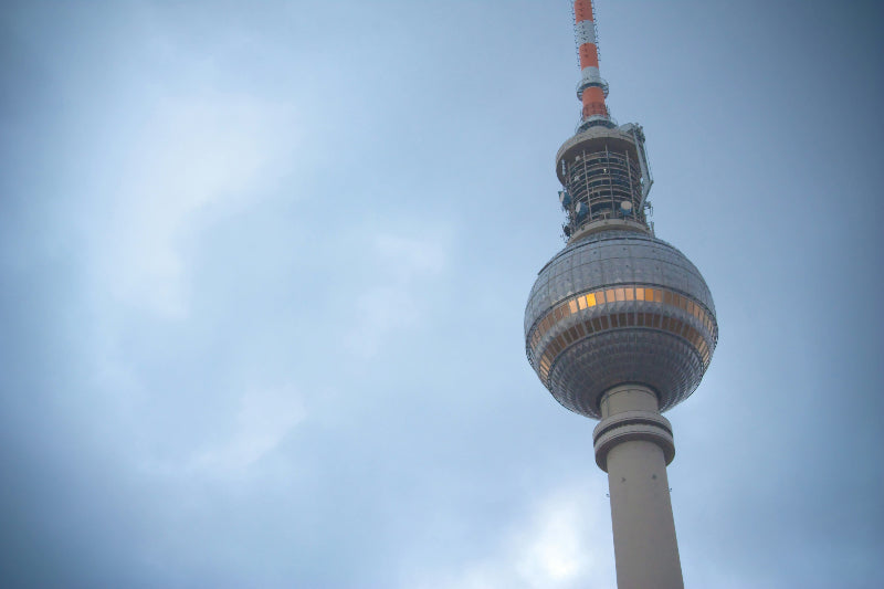 Nahaufnahme vom Fernsehturm bei bewölktem Himmel. 