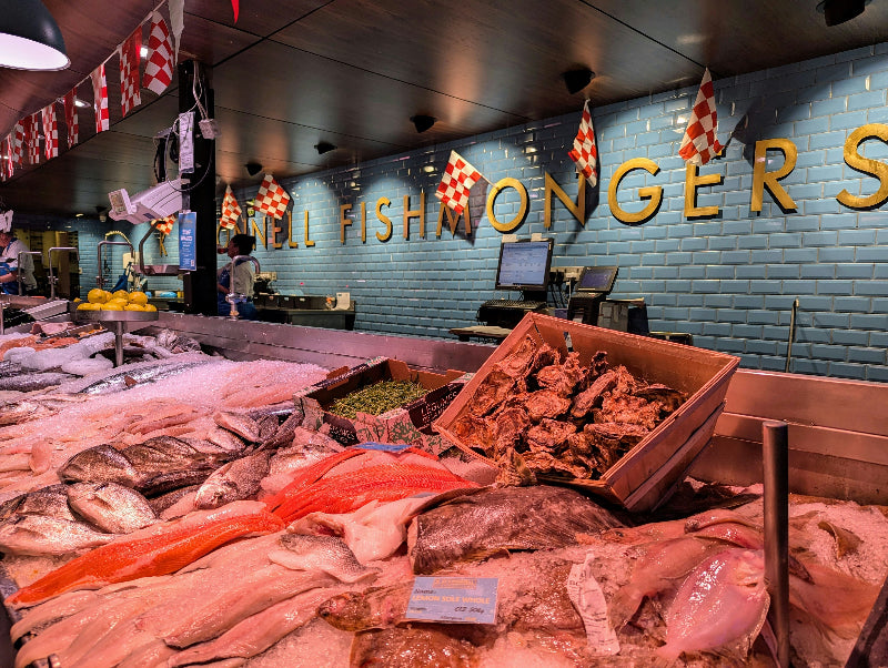 Foto vom Fischverkauf und der Frischetheke in einer Markthalle. 