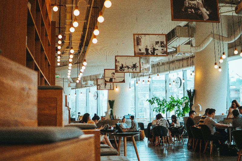 Foto von einem schön dekorierten Frühstücksrestaurant mit großen Fensterfronten. 