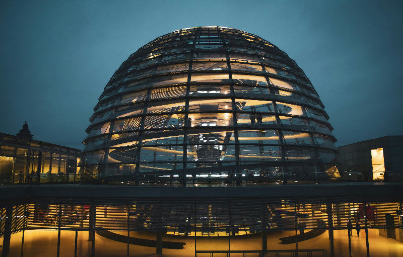 Glaskuppel vom Berliner Reichstag mit Besuchern bei Dunkelheit. 