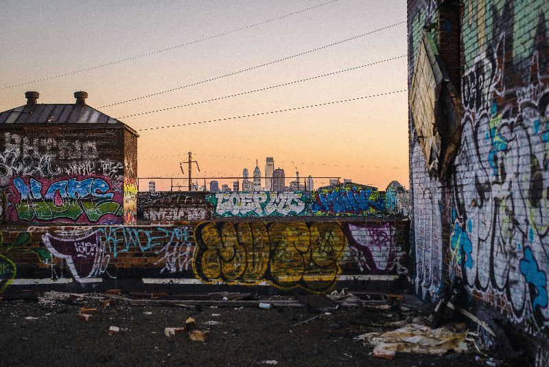 Foto von einem Hinterhaus voller Graffiti mit der Skyline von NewYork im Hintergrund. 