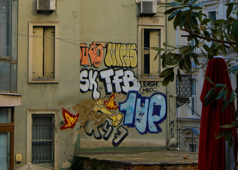 Foto von einem blauen 1UP-Schriftzug auf einer Hauswand in Berlin. 
