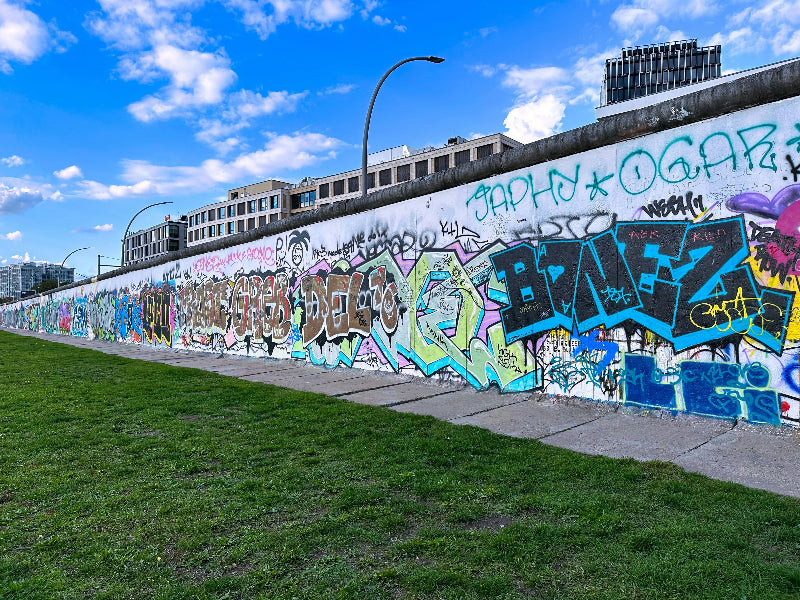 Foto von der Rückseite der Berliner Mauer mit vielen Graffitis. 