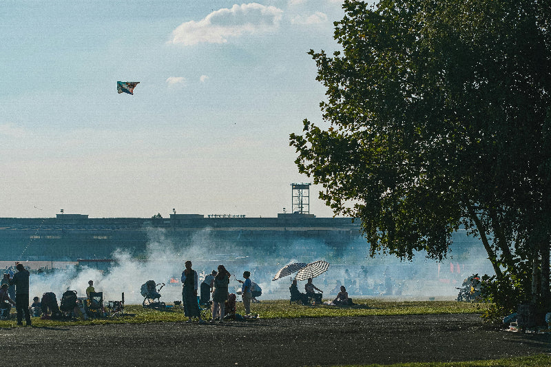 Viele Menschen beim Drachen steigen und grillen auf Flughafengelände vom Tempelhofer Feld. 