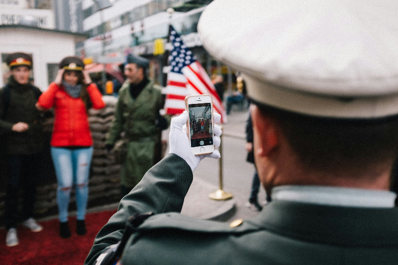 Soldaten und Besucher machen gemeinsames Foto vorm Checkpoint Charlie in Berlin. 