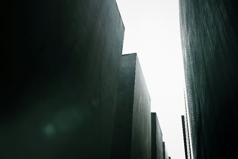 Dunkle Beton-Stelen der Holocaust Gedenkstätte mit hellem Himmel im Hintergrund. 