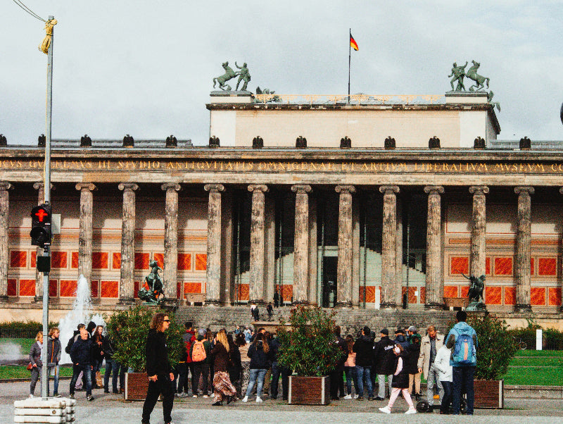 Lustgarten in Berlin mit vielen Besuchern, Straßenampel und altem Museum. 
