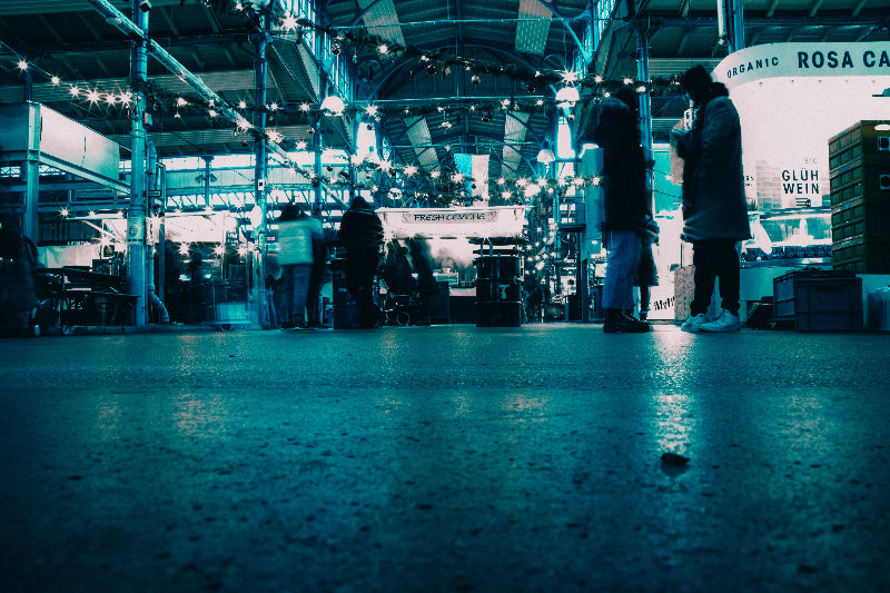 Foto vom Innenbereich der Markthalle 9. Fotografiert vom Boden mit verschiedenen Läden und Besuchern. 