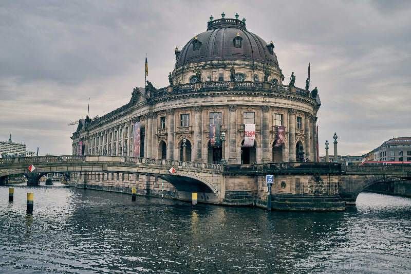 Foto von der Berliner Museumsinsel mit Bodemuseum und der Spree mit Brücke. 
