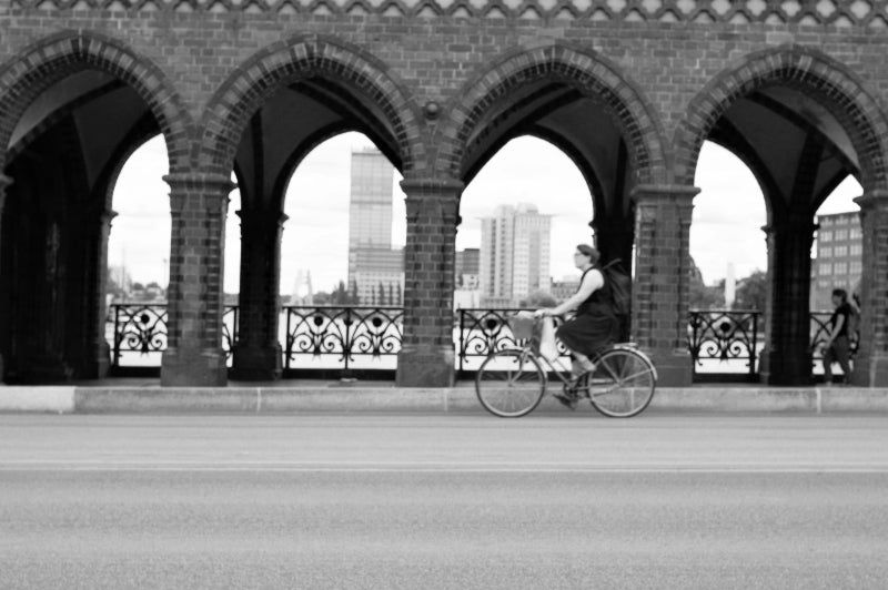 Foto von einer Radfahrerin auf der Oberbaumbrücke in schwarz weiss. 