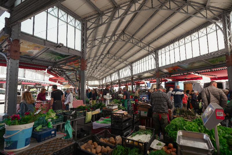 Foto von dem Innenbereich einer markthalle in Berlin mit Gemüse, Obst und vielen Besuchern. 