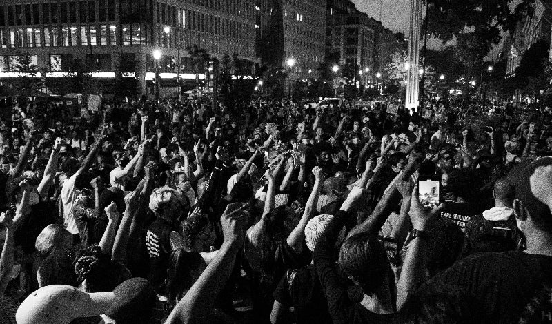 Schwarz-weiss Foto der Proteste von vielen menschen an der Weltzeituhr. 