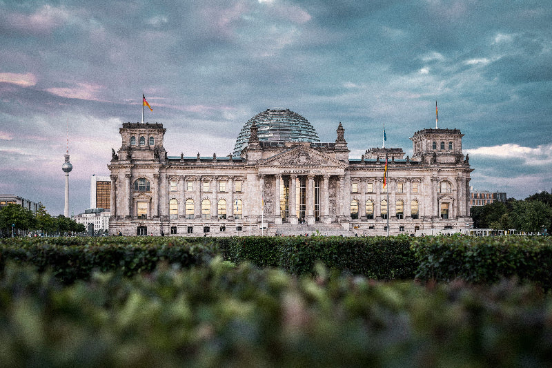Grüner Vorplatz mit Reichstagsgebaeude und Glaskuppel in Berlin.