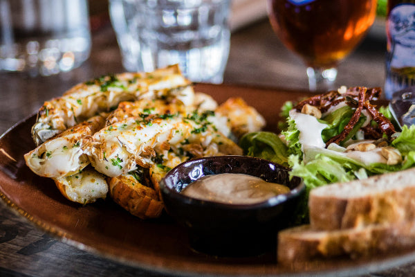 Gemischter Salat, Brot und frittiertes Gemüse auf einem Teller angerichtet. 
