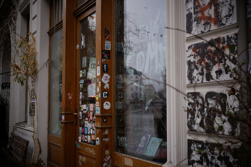 Foto von einem Schaufenster mit Stickern im Berliner Kiez. 