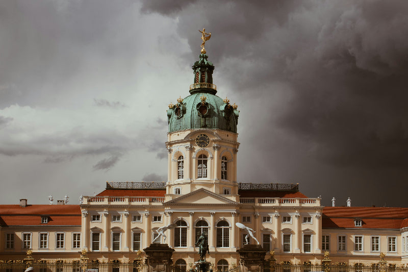 Hauptgebäude vom Schloss Charlottenburg mit Statuen und Zaun. 