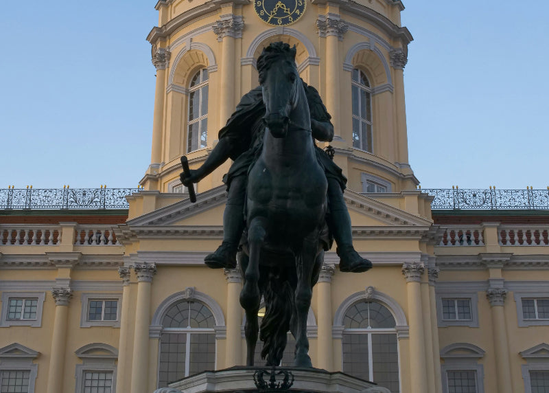 Reiter auf einem Pferd vorm dem Schloss Charlottenburg. 