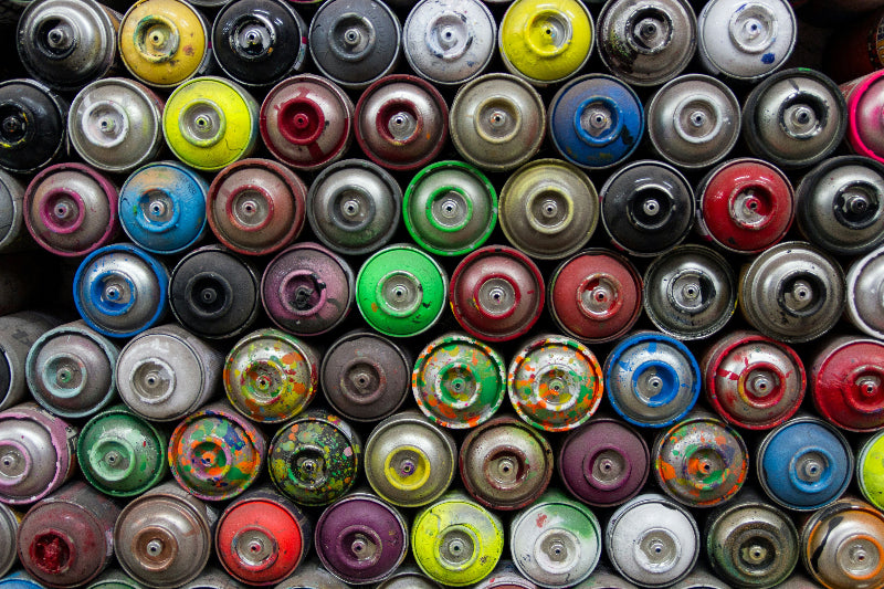 Foto von Dutzenden Spraydosen von oben ohne Cap fotografiert. 