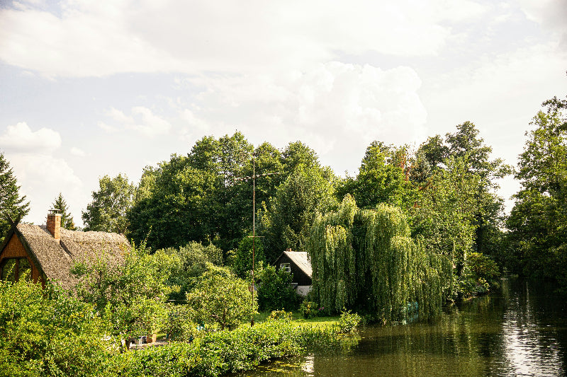 Foto vom einem Flussarm im Spreewald mit Häusern und Bewohnern.