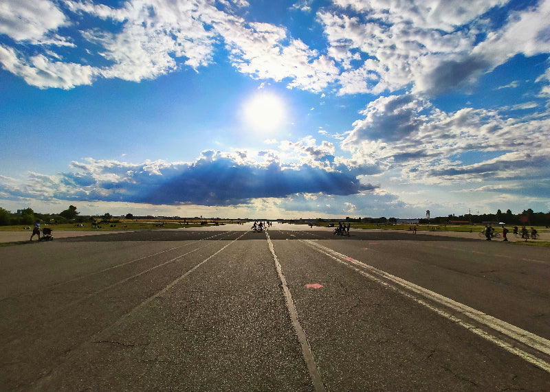 Foto vom Sonnenschein und strahlendem Himmel mit Besuchern und Landebahn auf dem Tempelhofer Feld. 