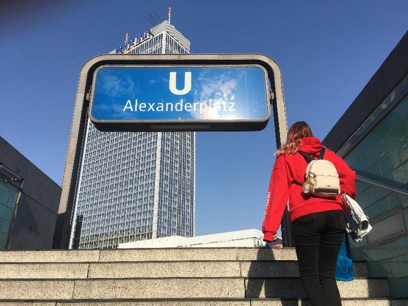 Ein Tourist läuft die Treppen am U-Bahnhof Alexanderplatz hoch. Im Hintergrund befindet sich Park-Inn-Hotel. 