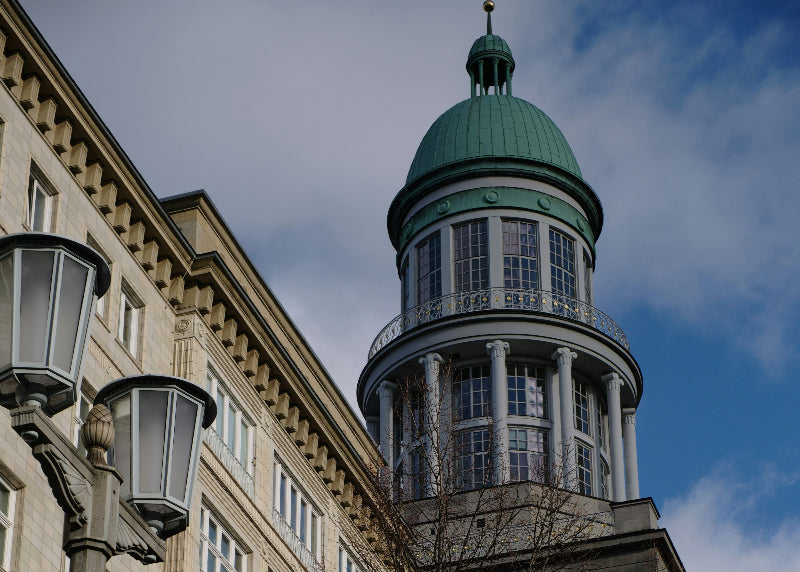 Nachaufnahme von einem der Türme am Frankfurter Tor inklusive DDR-Bau und alten Laternen. 