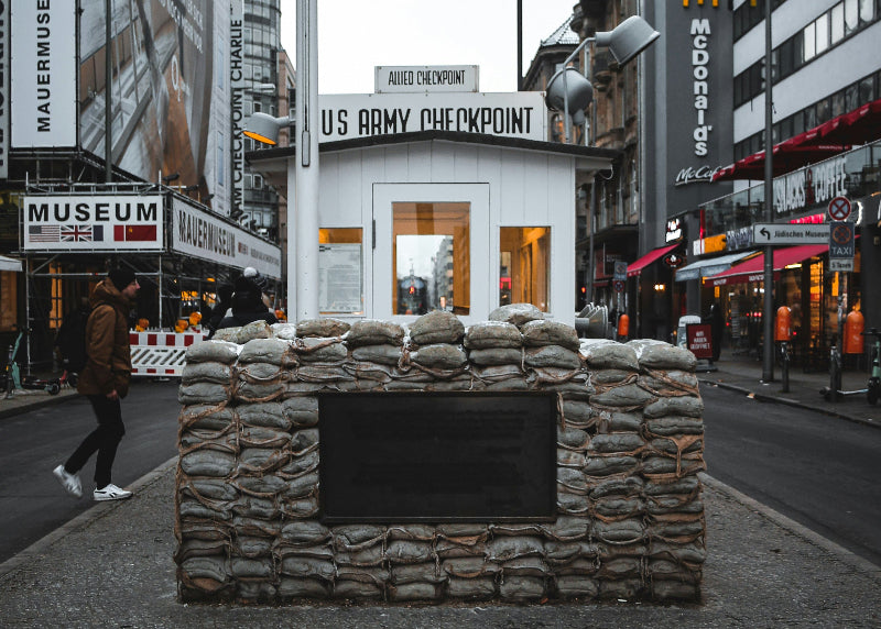 Museum und Checkpoint Charlie in Berlins Innenstadt bei bewölktem Himmel. 