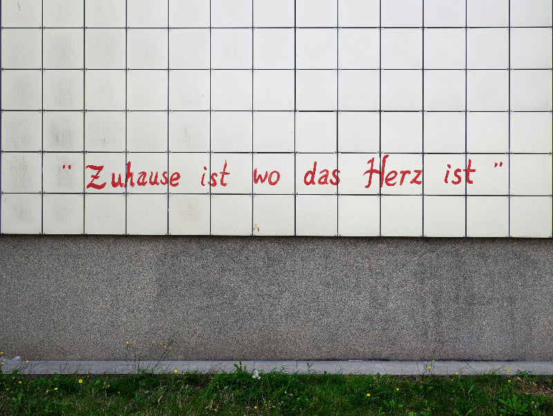 Aufschrift auf einem Plattenbau "zu Hause ist wo das Herz ist."