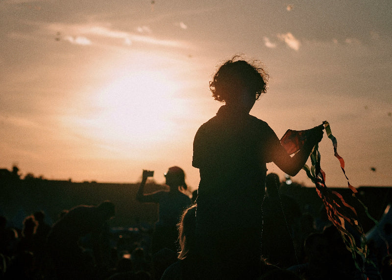 Kinder beim Drachensteigen bei Sonnenuntergang auf dem Tempelhofer Feld.