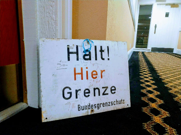Foto von einem Schild "Halt hier Grenze" in einer alten Berliner Wohnung.