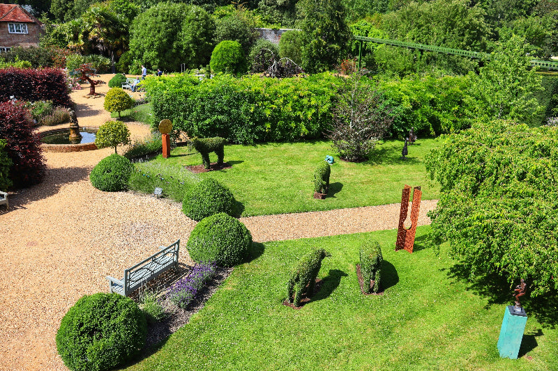 Foto von einem sehr gepflegten Gartenabschnitt mit Bäumen, Blumen und Pflanzen aller Art. 