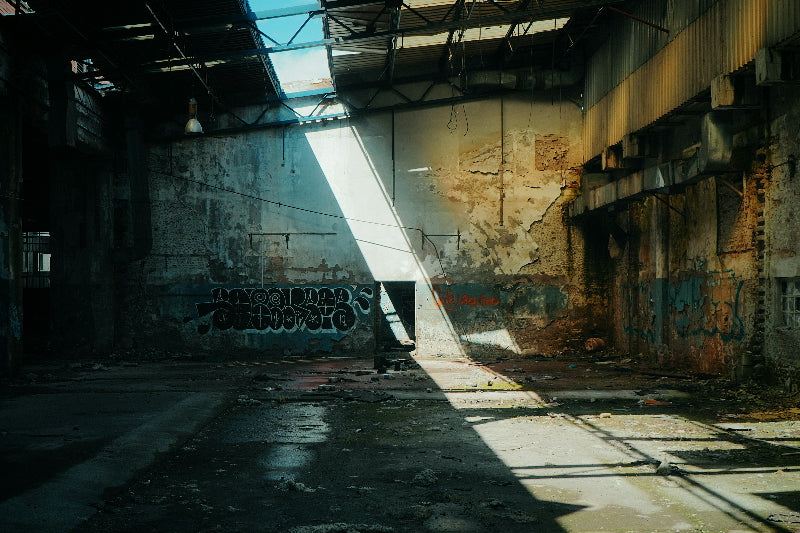 Foto einer besprühten alten Fabrik mit abgeblätterten alten Wänden. 