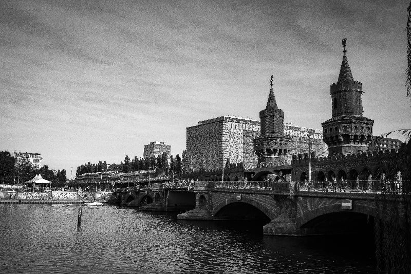 Foto in schwarz weiß von der Oberbaumbrücke von der Uferseite in Kreuzberg. 