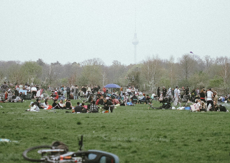 Foto von vielen menschen beim Picknicken auf einer Wiese auf alten Flughafengelände.